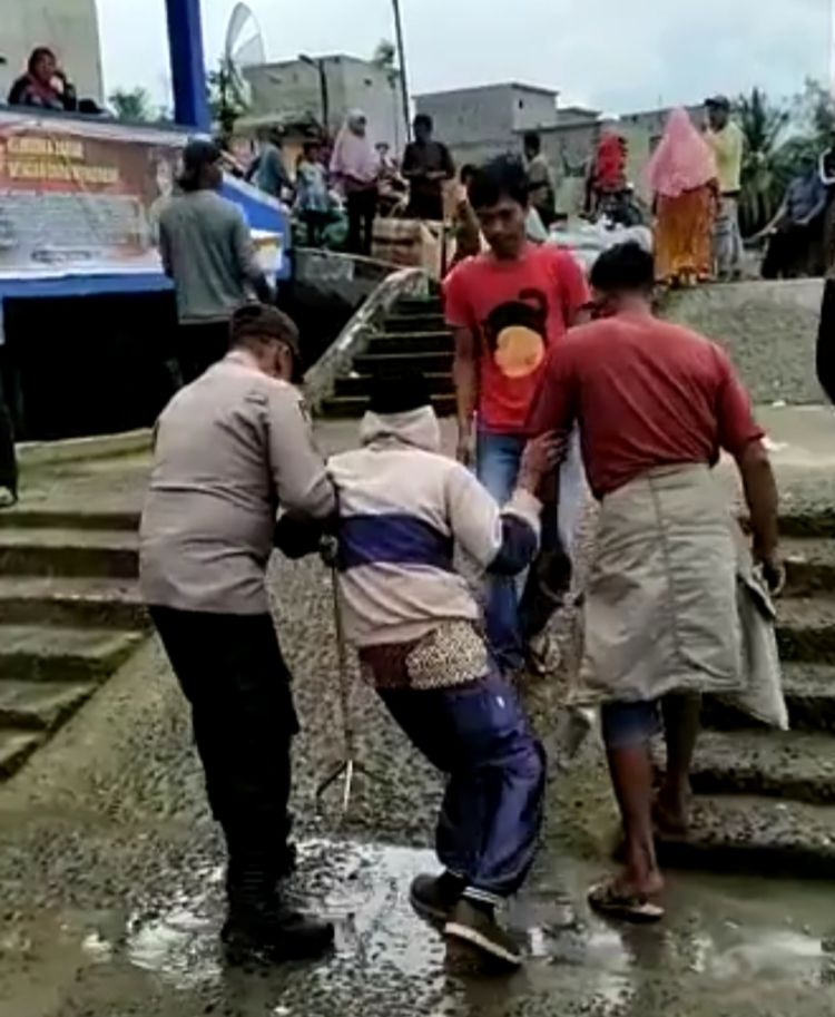 Waka Polsek Panai Tengah Bantu Pasutri Lansia Turun Dari Boat Penyeberangan